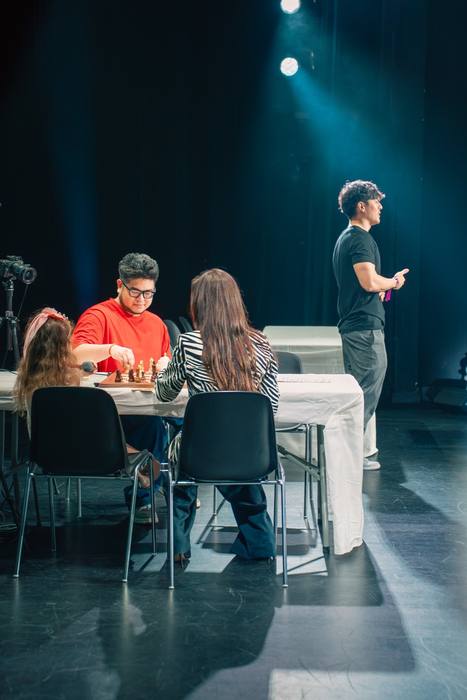 Chess Party, présentation sur scène devant la table de jeu, quatre joueurs assis sous les projecteurs
