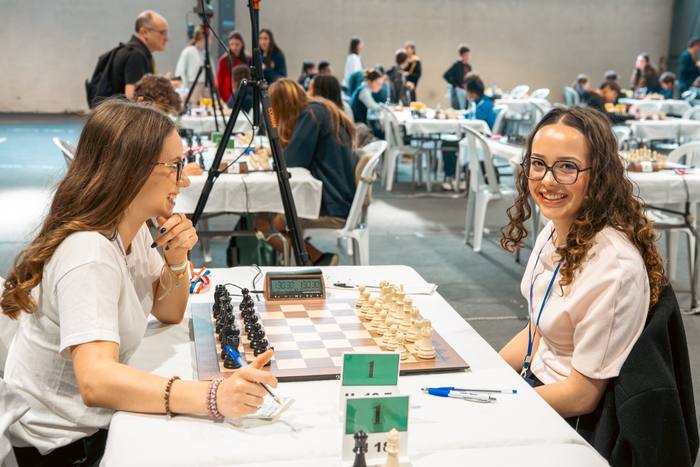 Deux joueuses notent leur partie de part et d’autre de la pendule
