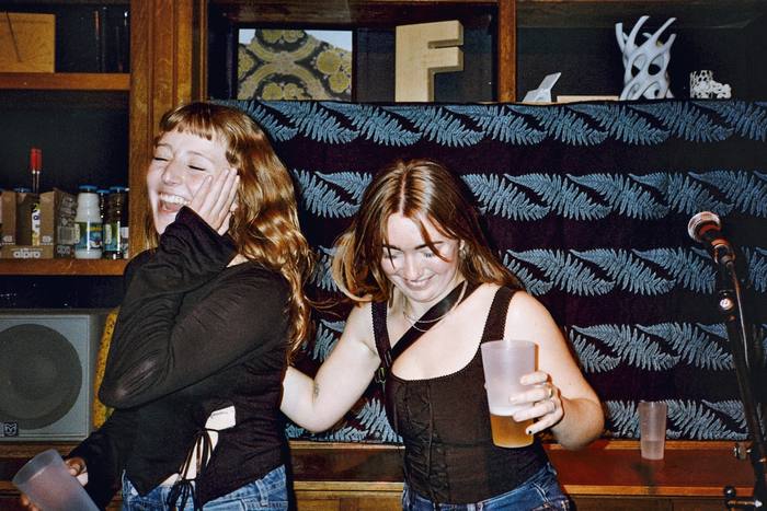 Deux chanteuses riant sur scène près du micro, photo argentique