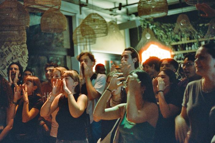 Public serré devant la scène, les mains en porte-voix pour reprendre le refrain, photo argentique