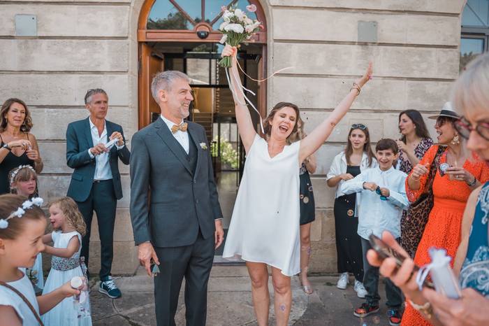 La mariée bouquet levé à la sortie de la mairie, bulles de savon
